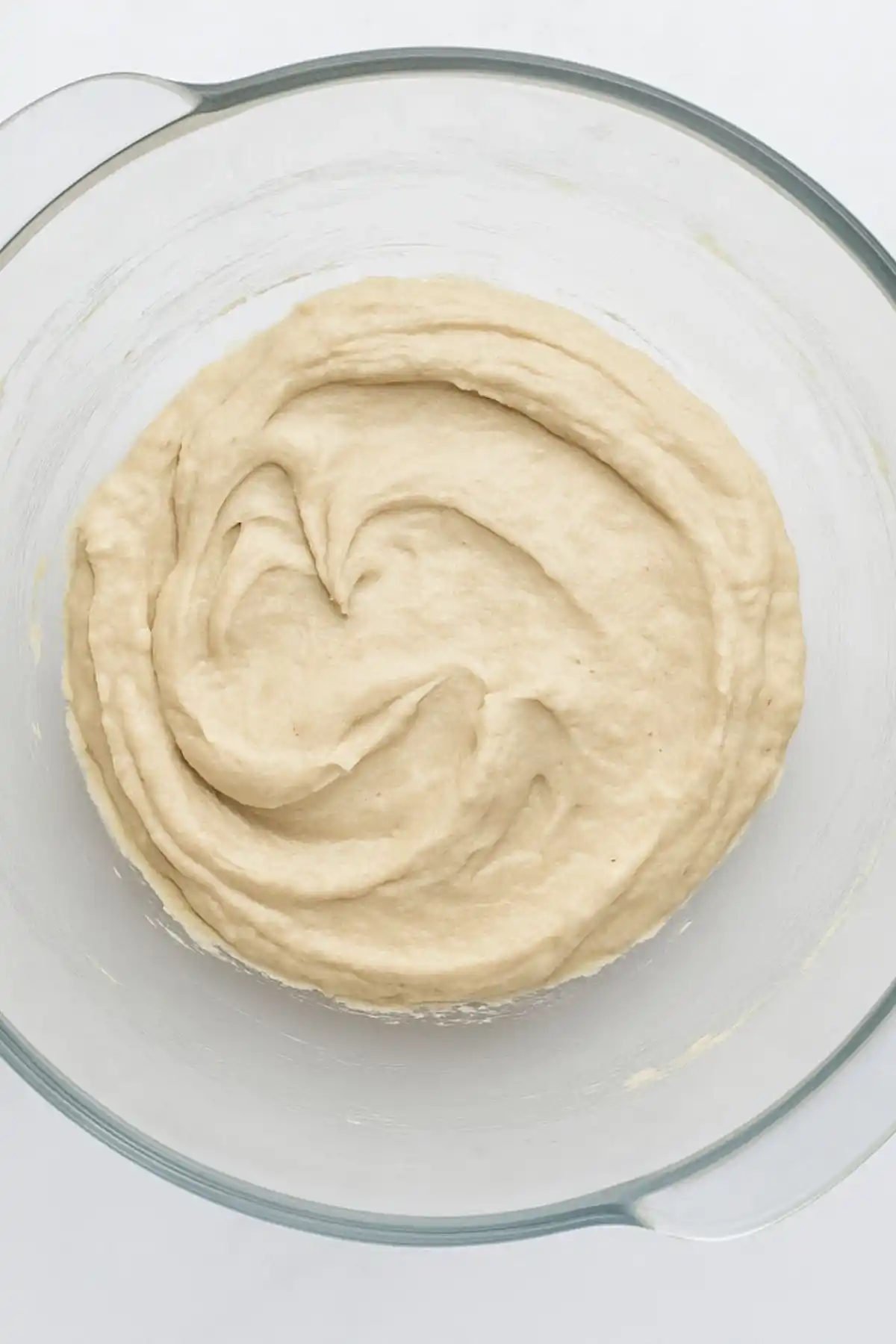 Thick mixed batter for gluten free sugar free bread in a glass mixing bowl, ready for baking.
