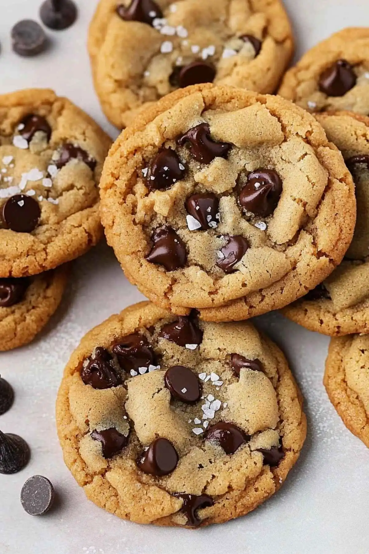 Gluten and dairy free chocolate chip cookies topped with sea salt on a white background.